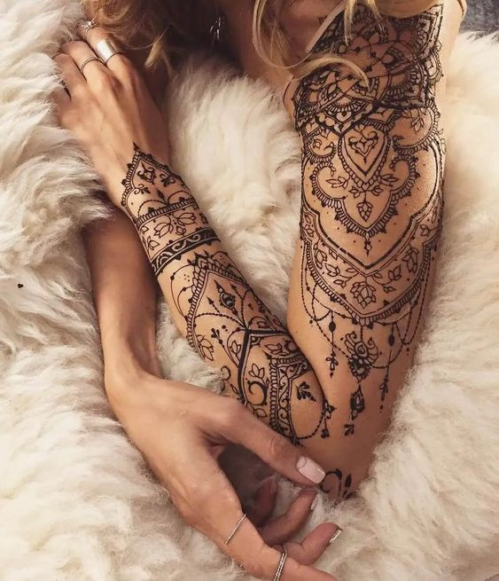 a tribal sleeve tattoo on a woman's arm