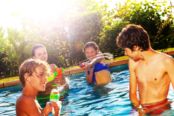 Kids having a water gun fight in a swimming pool