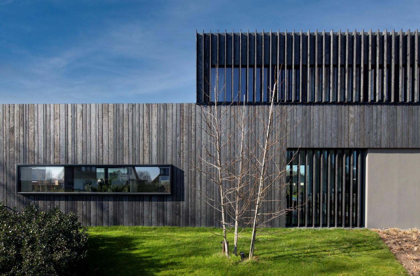 Дизайн современного дома с деревянным фасадом в черном цвете