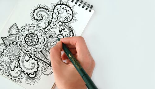 Person Holding Black Pen Sketching Flower