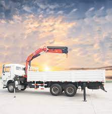 A SANY truck mounted crane parking under the sky. The crane of the truck is mounted, and the sky is full of clouds covering the sunlight.