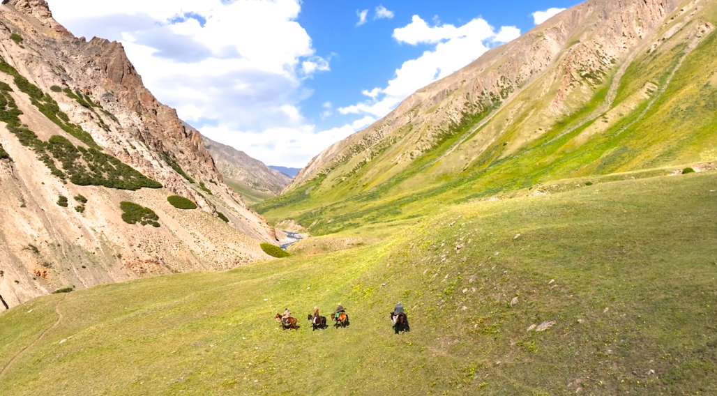Hunters on horseback in a valley