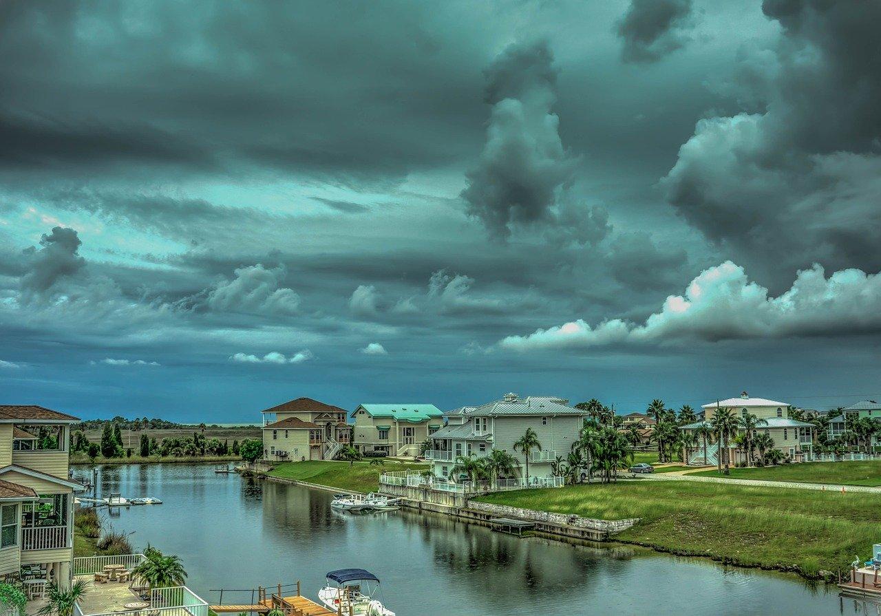 Waterfront homes and a cloudy sky. 
