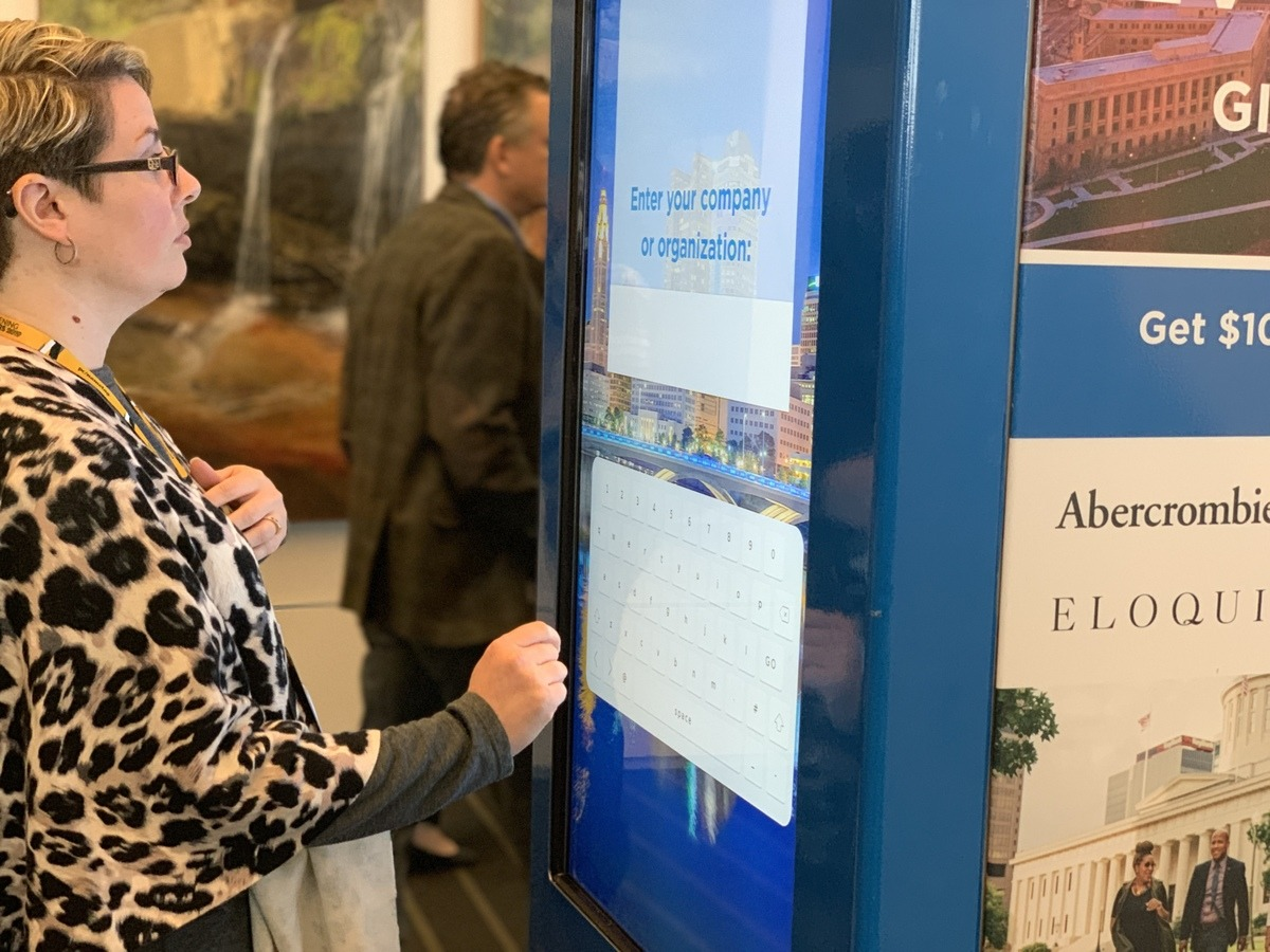 Woman using interactive vending machine survey with data collection at trade show event