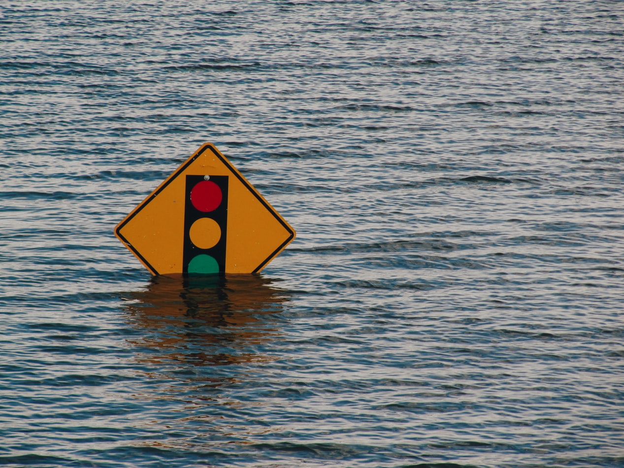 An image of a traffic light sign in the middle of flood waters