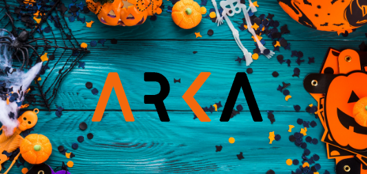 Halloween at Arka with a green background and encircled by Halloween decor in orange and black as pumpkins, cobwebs, confetti and skeletons. 