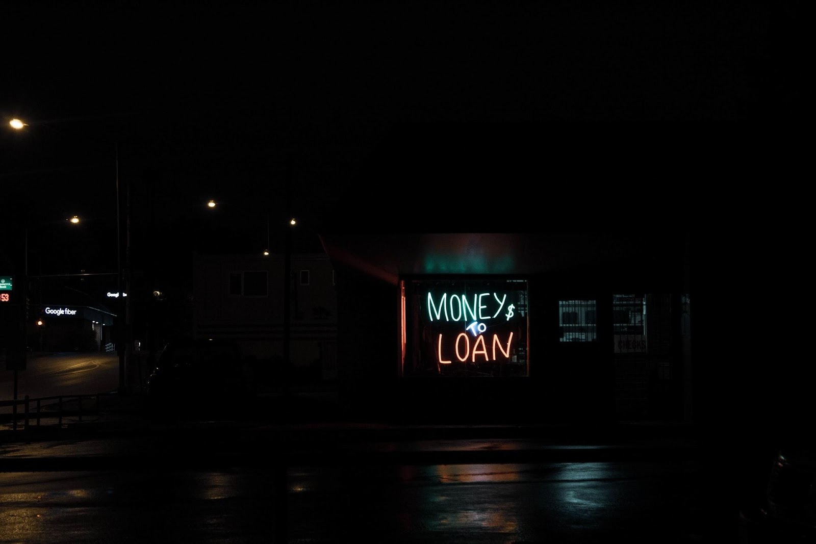 A picture of a sign saying money to loan in bright neon letters.