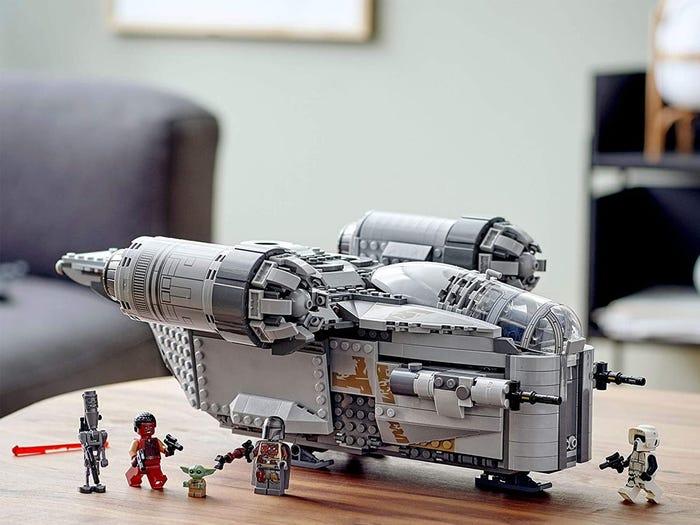 Lego Star Wars The Mandalorian The Razer Crest assembled on coffee table with mini figures positioned around it - best gifts for tweens who love star wars