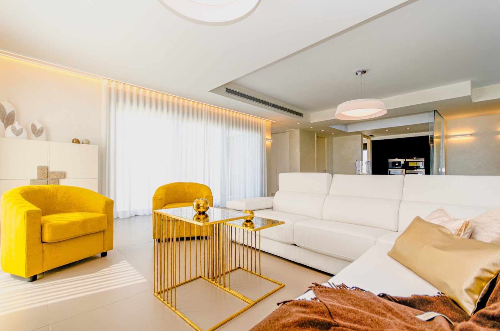 Neutral living room with mustard armchair and brass accents