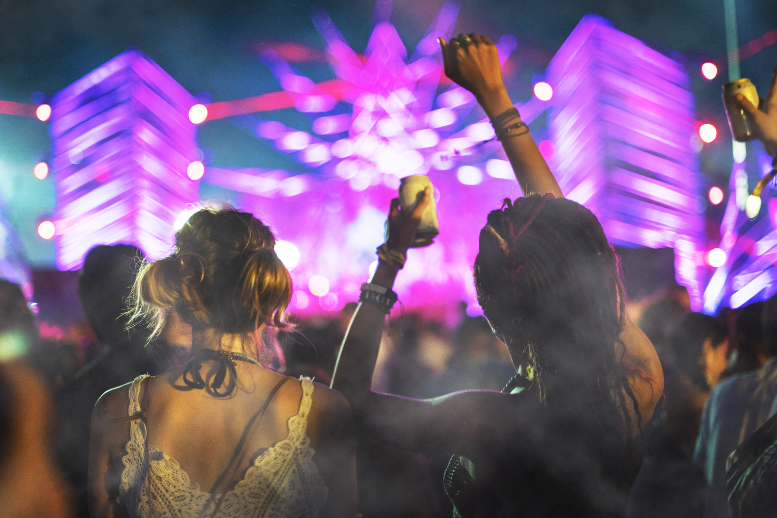 duas amigas dançando em um festival usando camiseta de banda