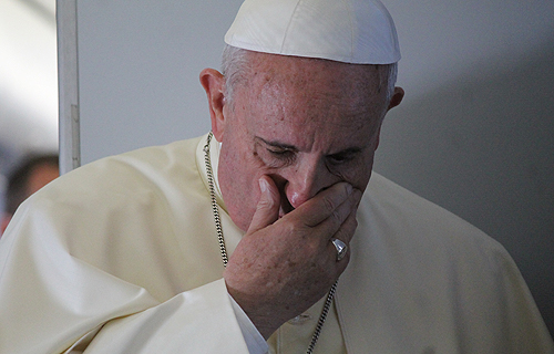 Pope Francis prays with journalists on the papal plane, August 14, 2014. Credit: Alan Holdren/CNA.