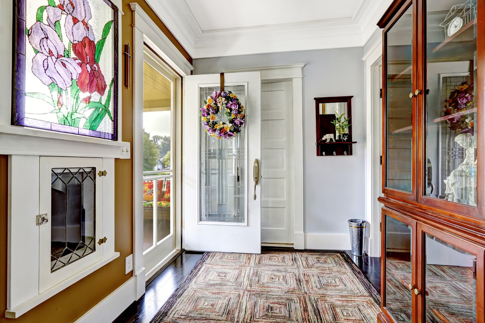 An open white door with glass insert in entryway