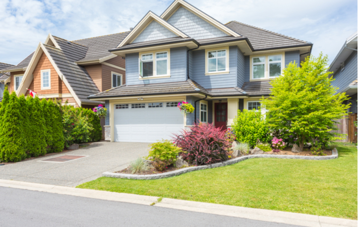 a photo of a blue house with a well-kept yard