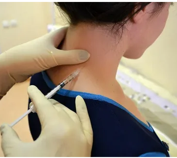 A person injecting a person's neck

Description automatically generated