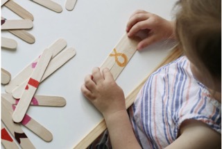 A child playing with popsicle stick puzzles