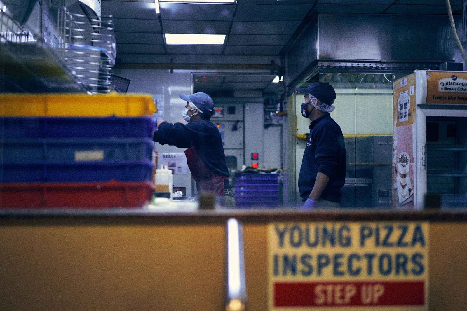 Employees  preparing customer orders in Domino's Pizza, a popular restaurant franchise.