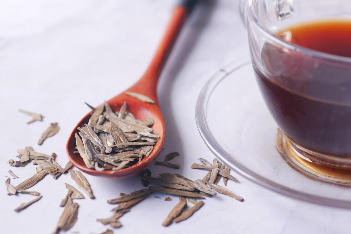 Free Herbs on a Spoon and a Cup of Tea Stock Photo