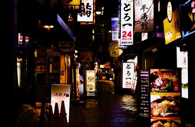 多くの看板が立ち並ぶ飲み屋街の写真