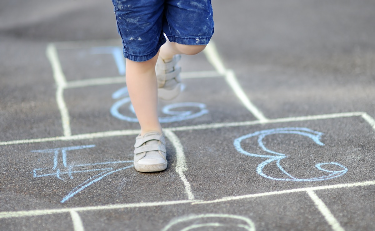 Close-up on the feet of a child playing hopscotch