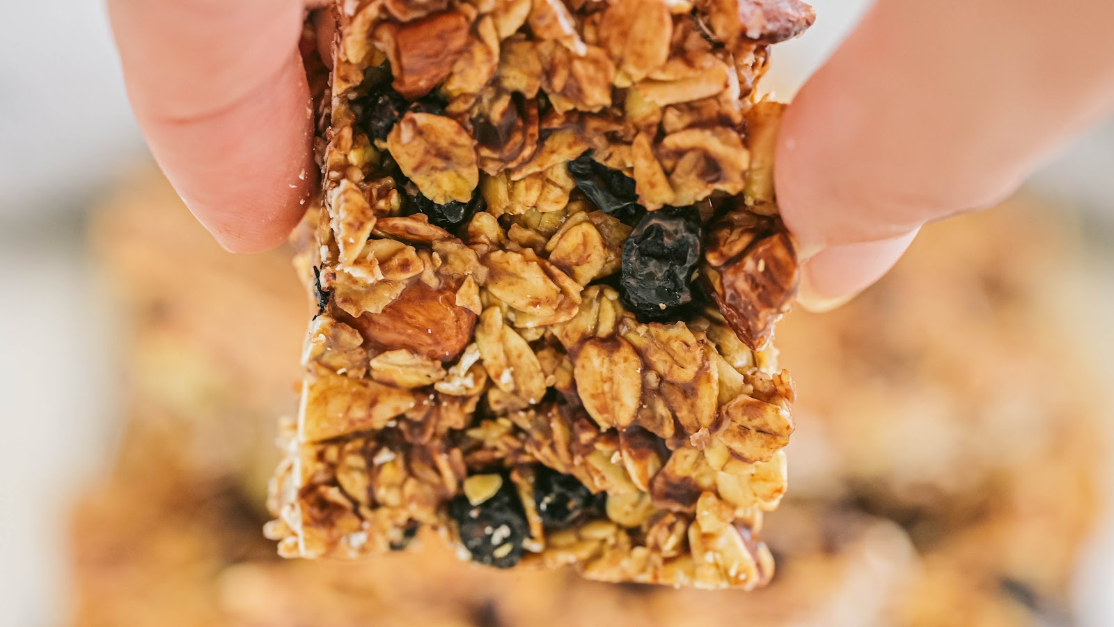 close up of fingers holding a homemade granola bar