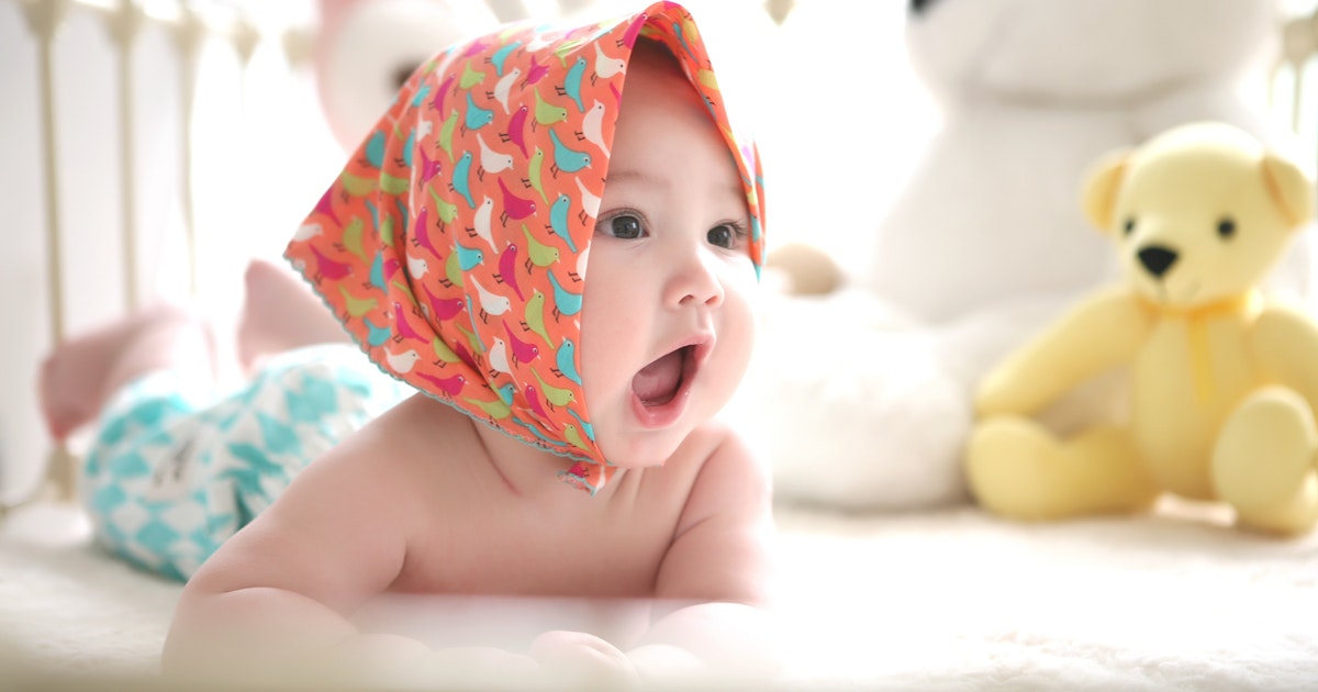 Cute baby in crib wearing bandana