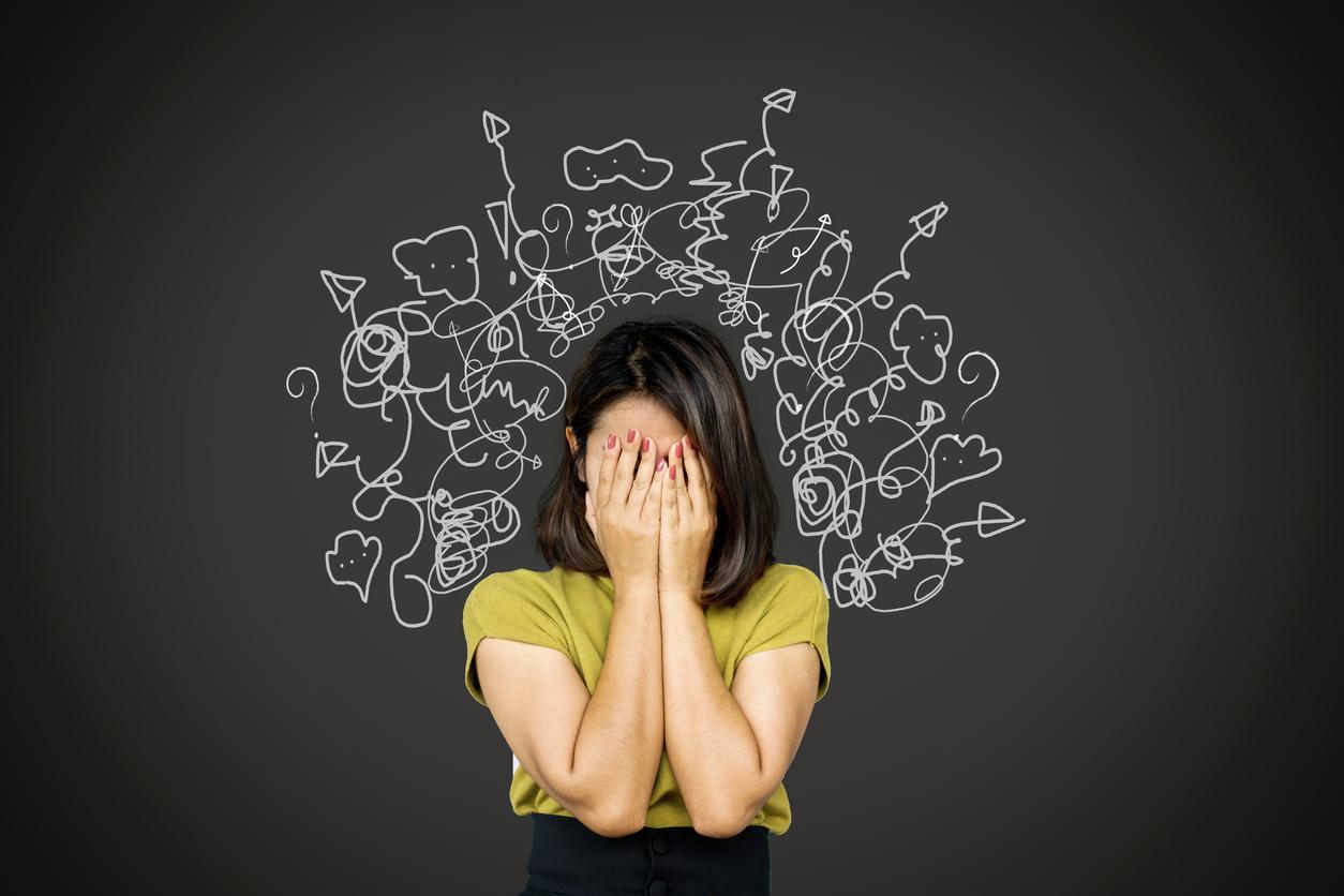 Woman standing in front of drawings showing stress and intrusive thoughts