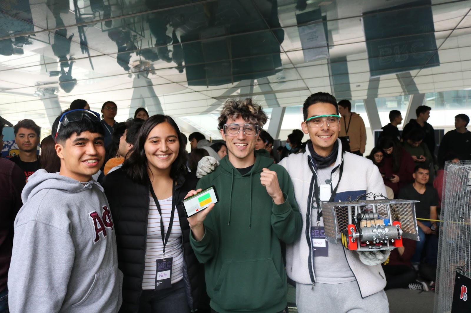 Una mujer y tres hombres estudiantes mostrando su robot que les valió el primer lugar