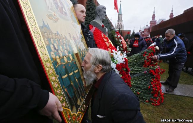 Відзначення дня народження Йосипа Сталіна на його могилі біля Кремлівської стіни на Червоній площі. Чоловік цілує ікону із зображенням радянського диктатора. Москва, 21 грудня 2015 року