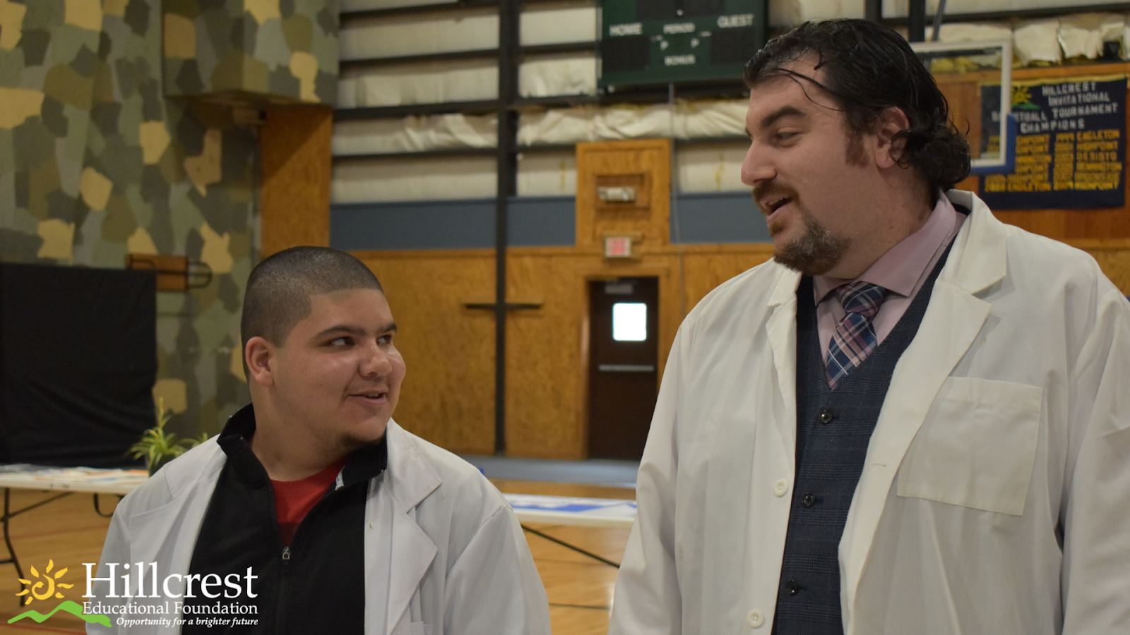 Mr. Quinlan and one of his students wearing matching lab coats at the art & science fair at Highpoint.