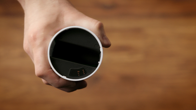 A person screwing the top cover of the Outdoor Camera back onto the body of the camera, highlighting that the smaller piece with the camera lens on it screws on and off with ease.
