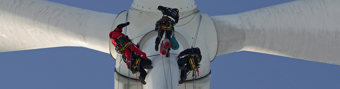 Rope-access technicians working their way down a turbine 