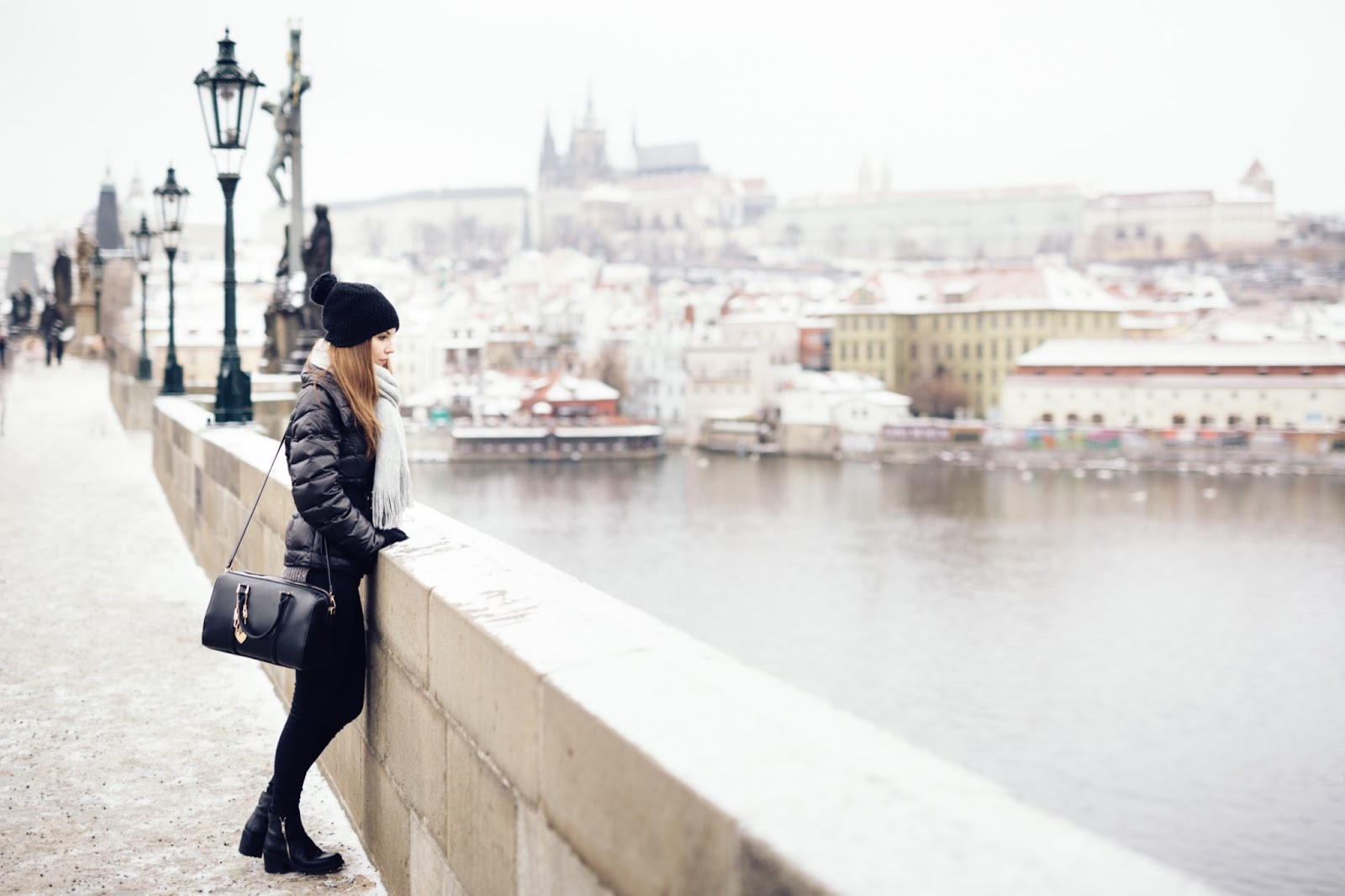 Woman looks over bridge in Prague, European cities winter