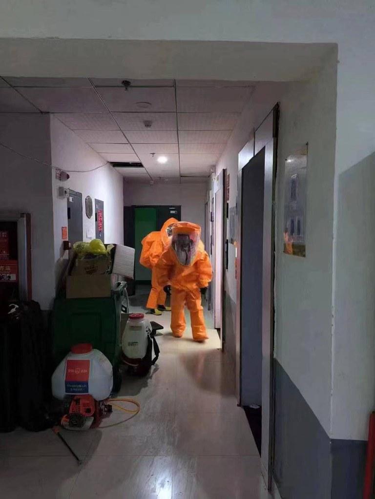 社區出現了陽性病例後，重裝防護的消殺人員開始對居民樓進行消殺。（知情人提供）