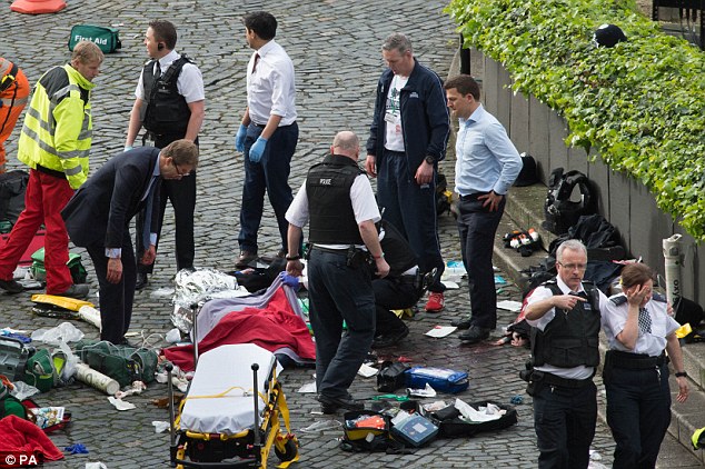 A police officer is led away from the scene after she tries to revive her colleague who was stabbed in the attack on Wednesday afternoon