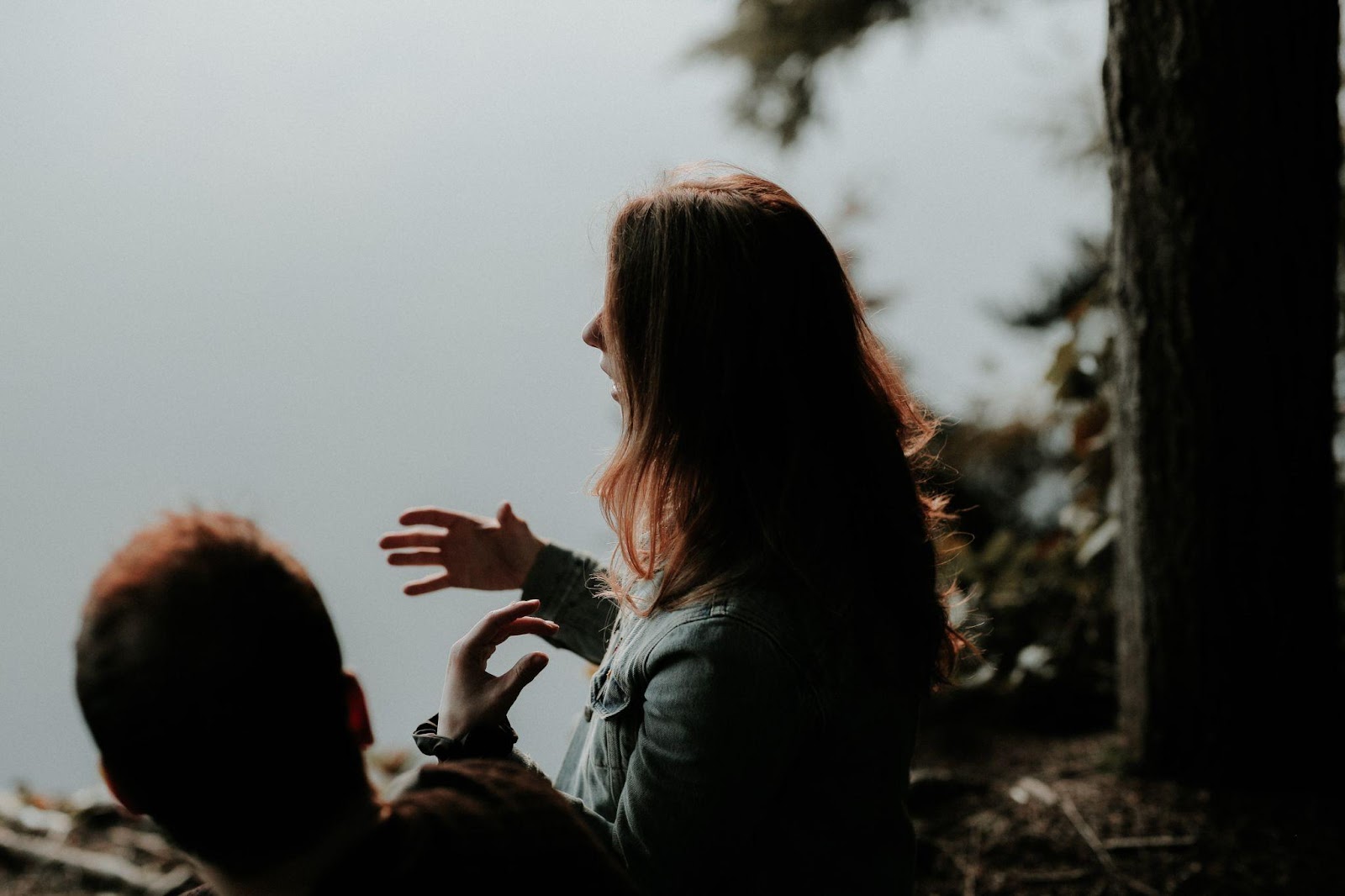 Two People in a Forrest and a Woman Looking Like She's Talking