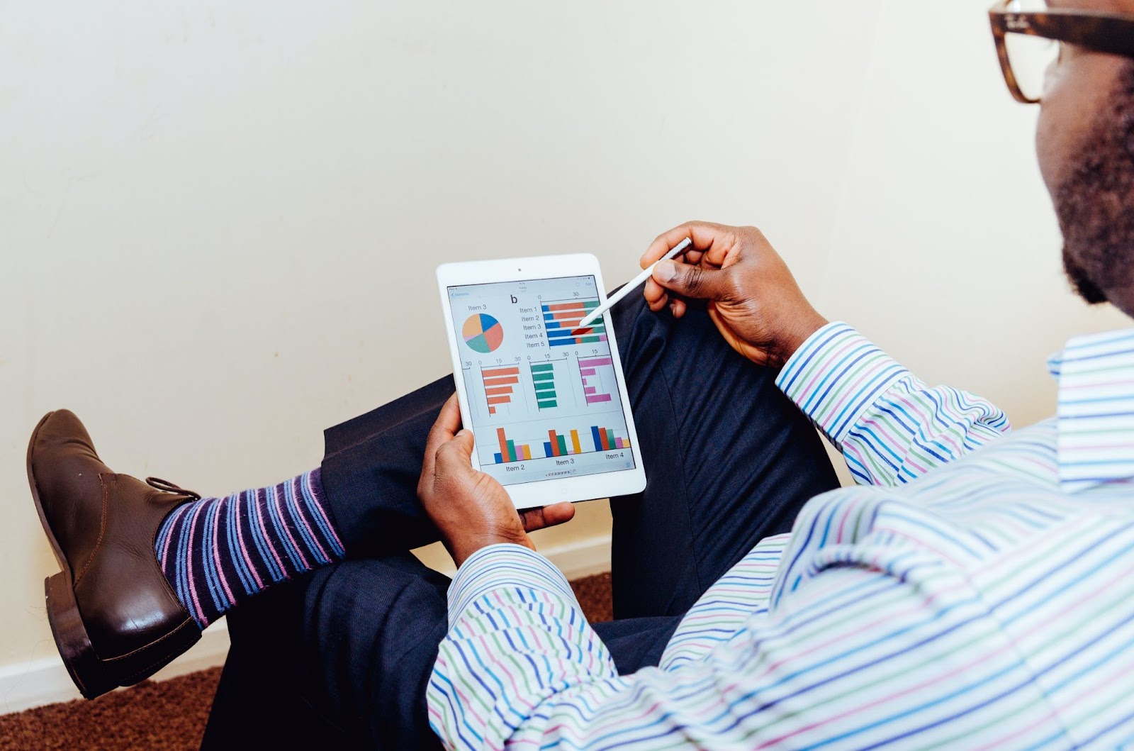 man holding a tablet looking at graphs