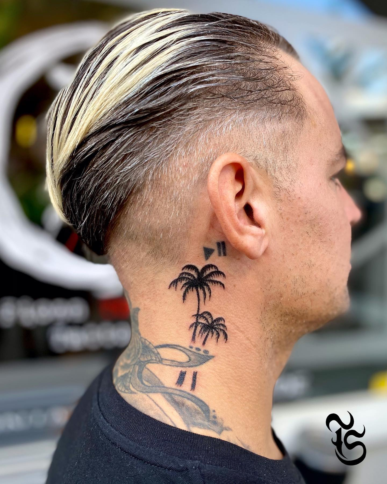 Side view of a guy rocking the palm tree tattoo on the neck