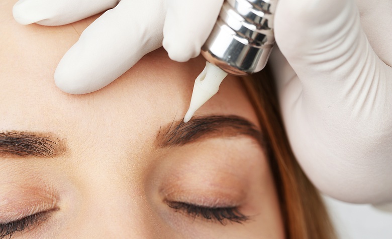 Cosmetologist making permanent makeup, close up