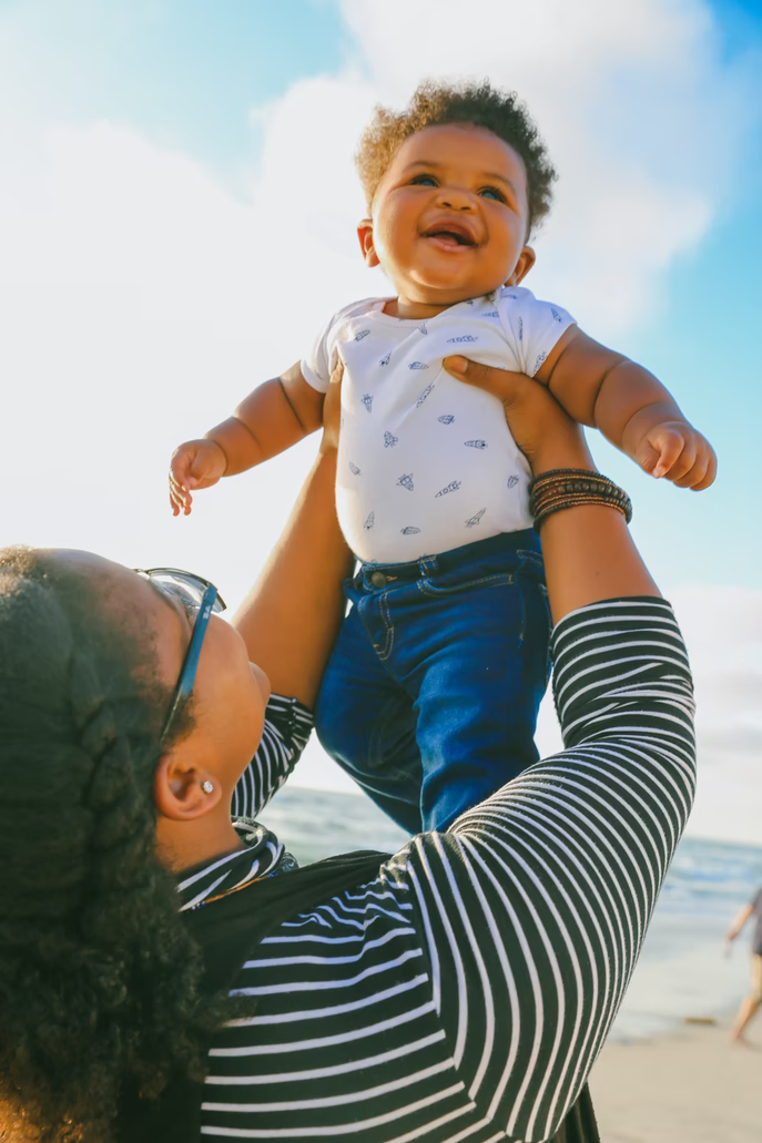 Child lifted overhead of caregiver