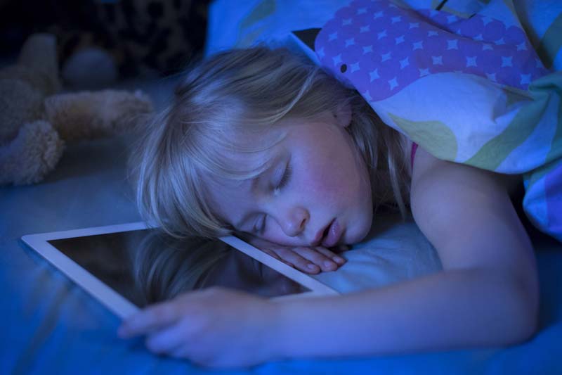 A child using an iPad before sleep.