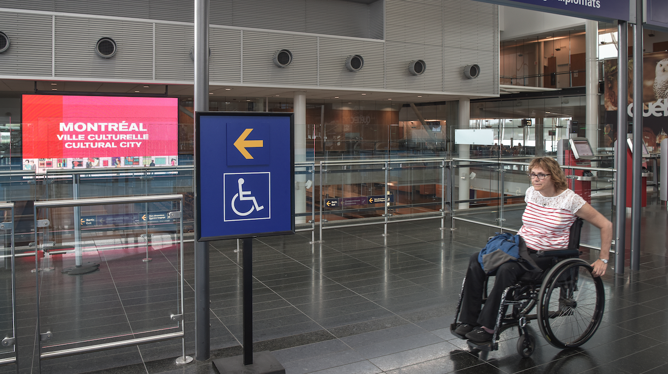 Personne en fauteuil manuel se déplaçant à l'aéroport