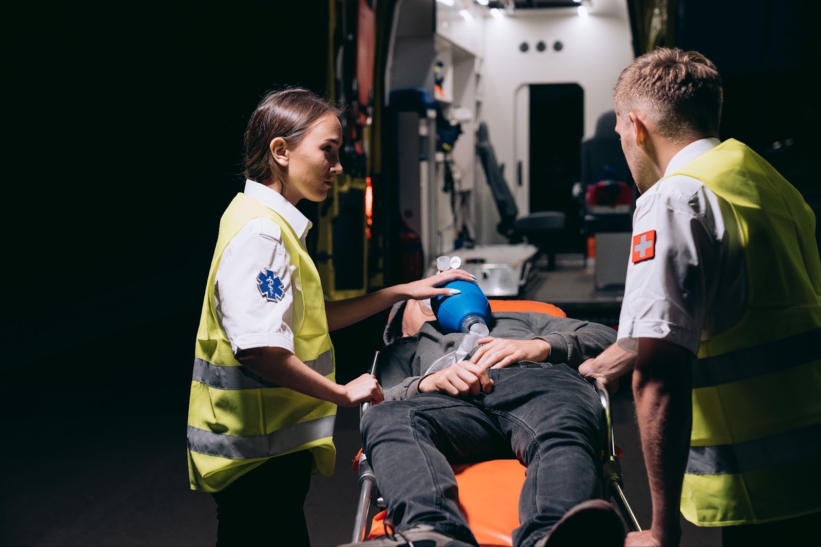 paramedics giving first aid to an injured person lying on a stretcher