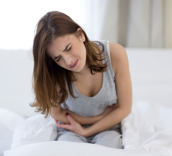 Đau bụng kinh là một trong những triệu chứng rối loạn kinh nguyệt do dùng thuốc tránh thai