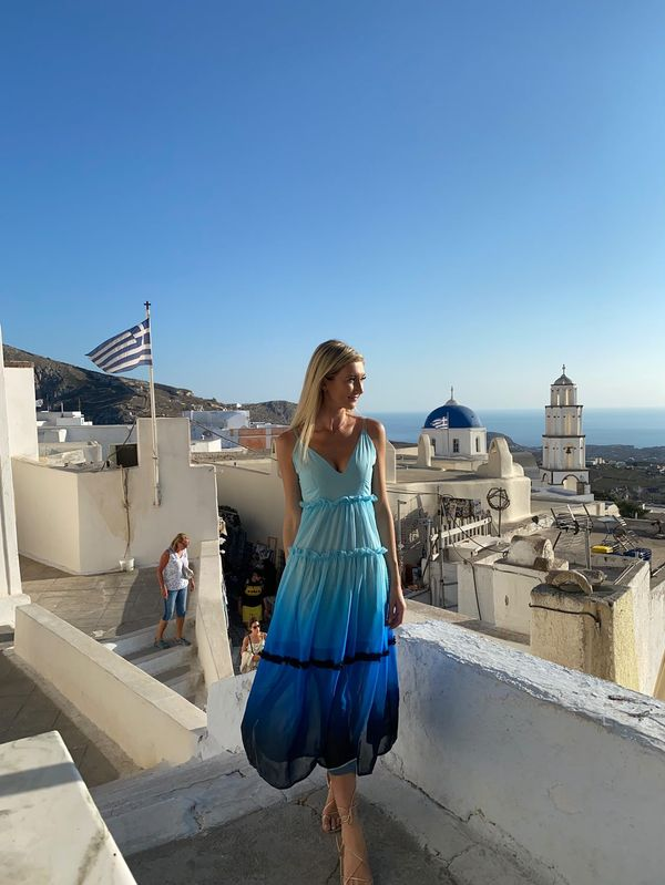 A girl posing in front of the Santorini cityscape