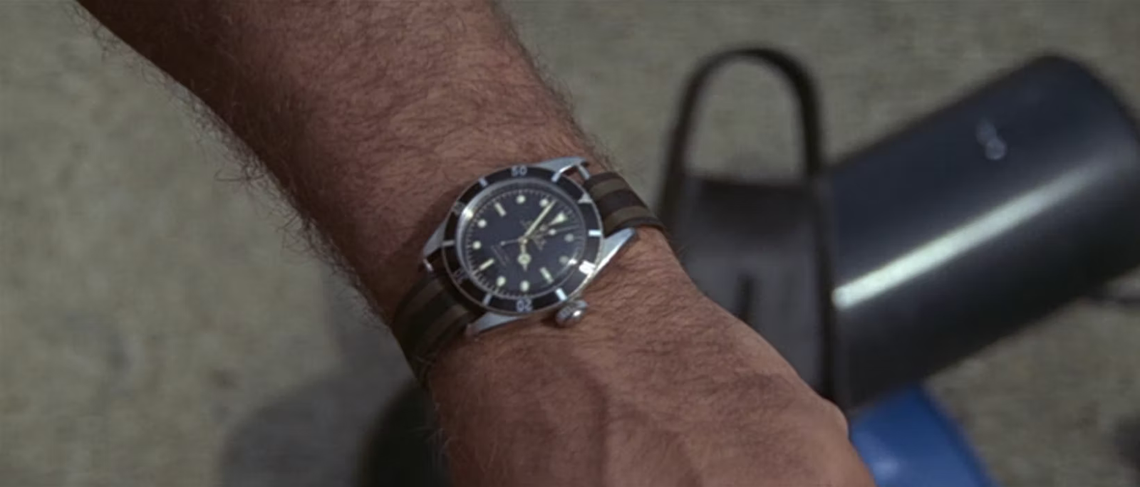 Rolex Submariner with a nylon strap on James Bonds' left wrist.
