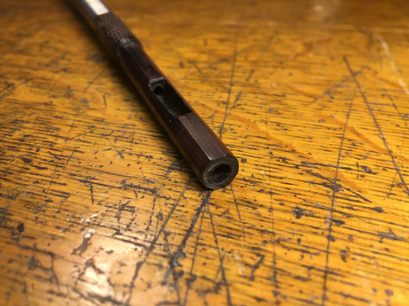 Violin bow with damaged holes.