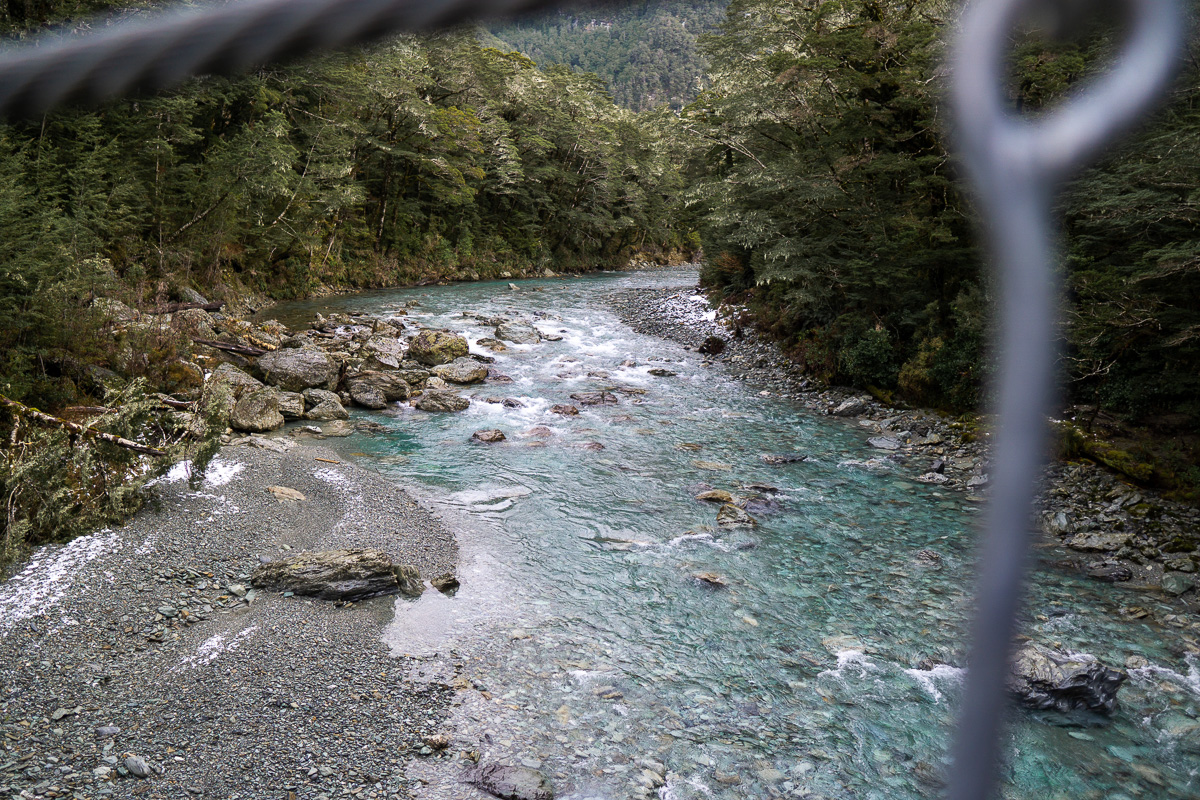 在新西兰路特伯恩步道徒步旅行时，穿过铁丝网观看河流的景色