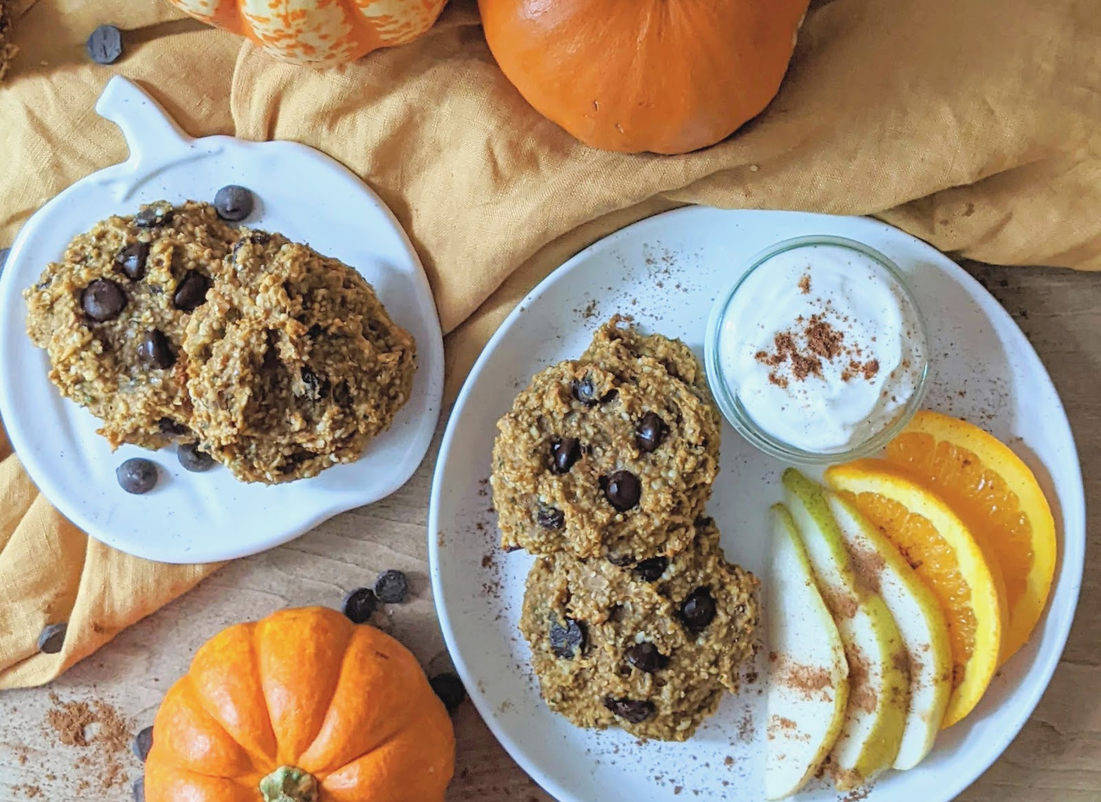 top down view of cookies on plates with fruit and pumpkins