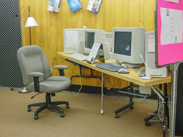 A corner table with two 90s style computers. 