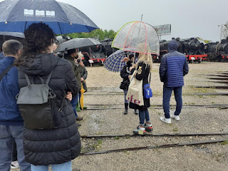 Visitants al pati del museu, sota paraigües
